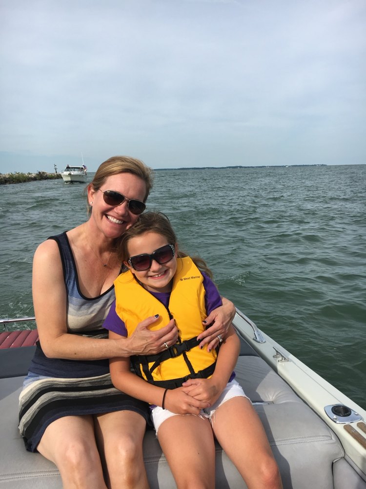 Family time on the water — a grandmother and granddaughter in a yellow life vest out on Lake Erie