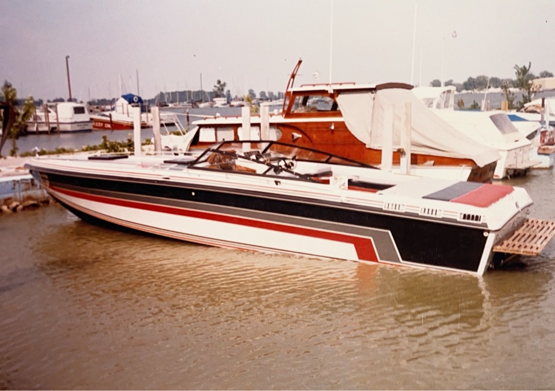 A vintage offshore boat tied up at the marina in West Harbor Club's early years, a wooden cruiser behind it